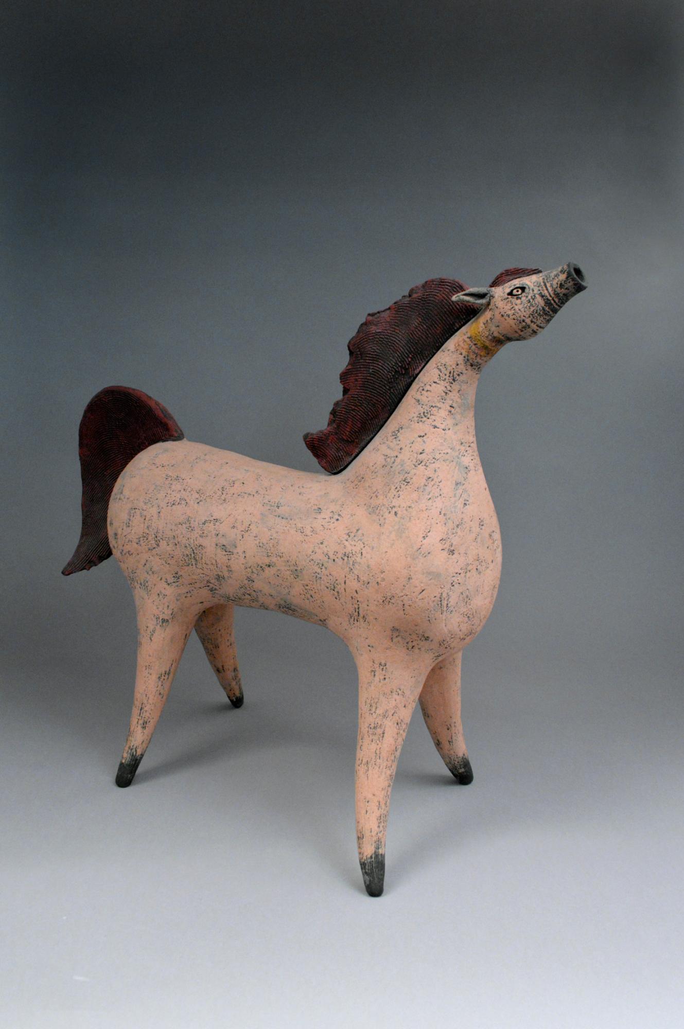 Small, stylized statue of a vigorous and whimsical horse, made of glazed and fired clay.
